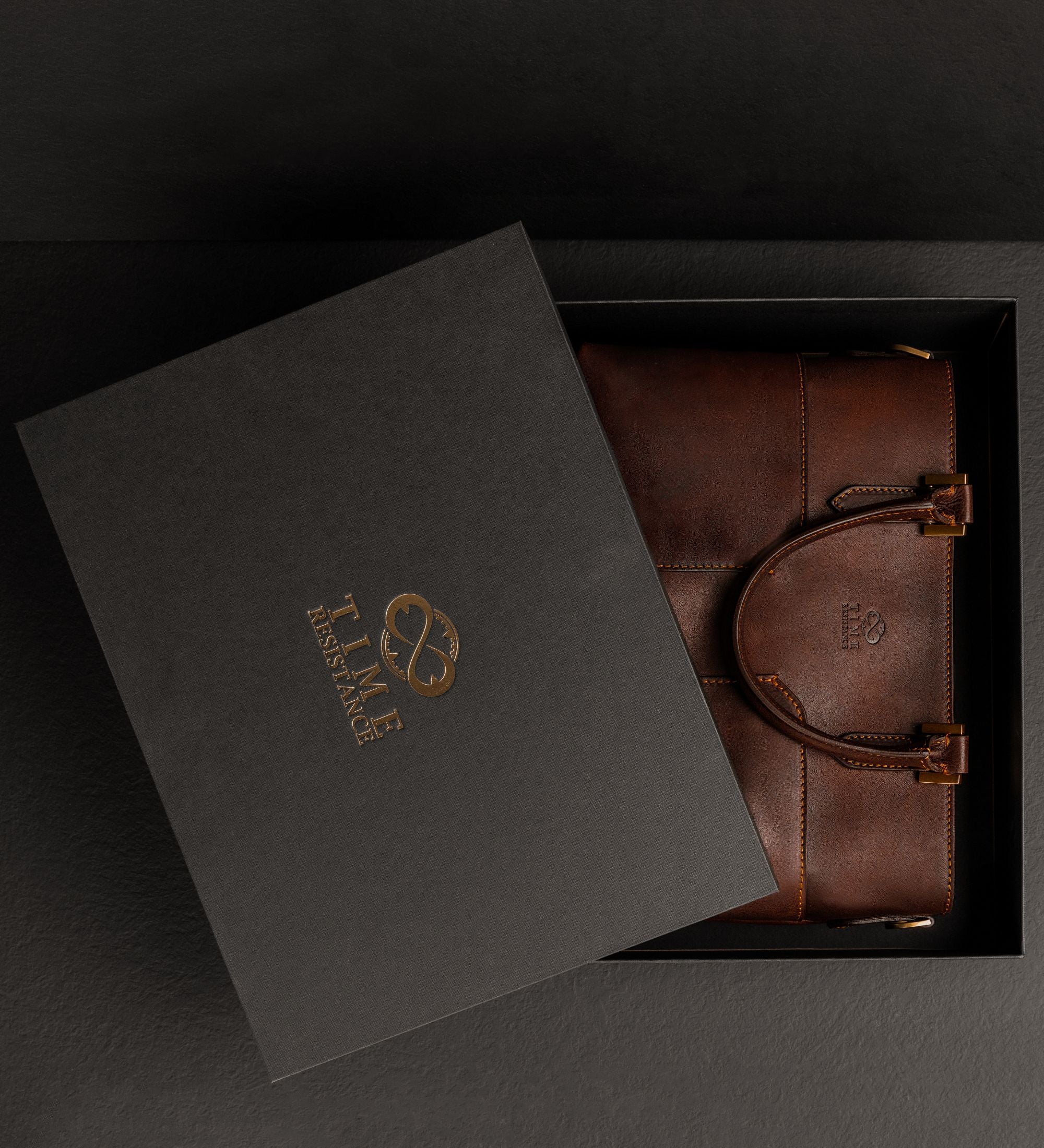 Geöffnete schwarze Geschenkbox mit der schokoladenbraunen Camilla Schultertasche aus Leder darin