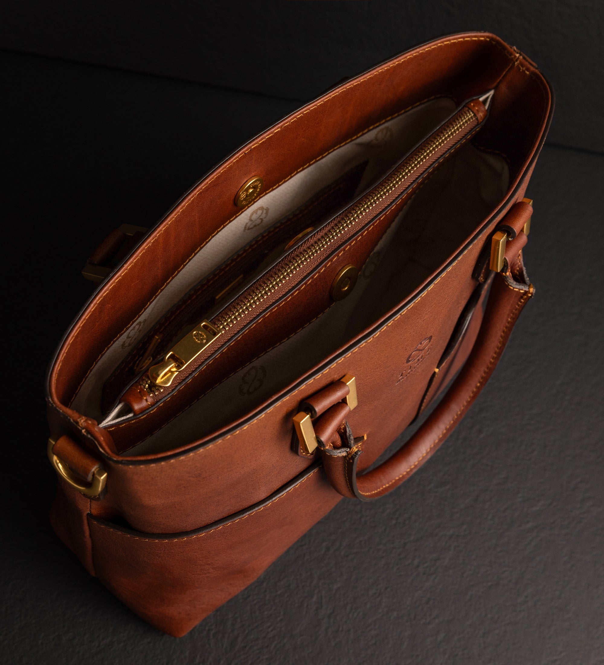 Cognacbraune Camilla Schultertasche von oben geöffnet, mit Reißverschlusstasche und Innenfutter