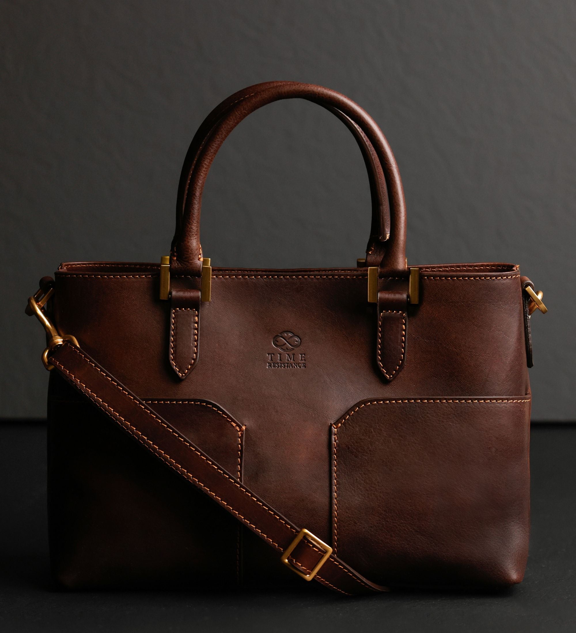 Schokoladenbraune Camilla Schultertasche schräg gezeigt, mit ausgezogenem Crossbody-Riemen