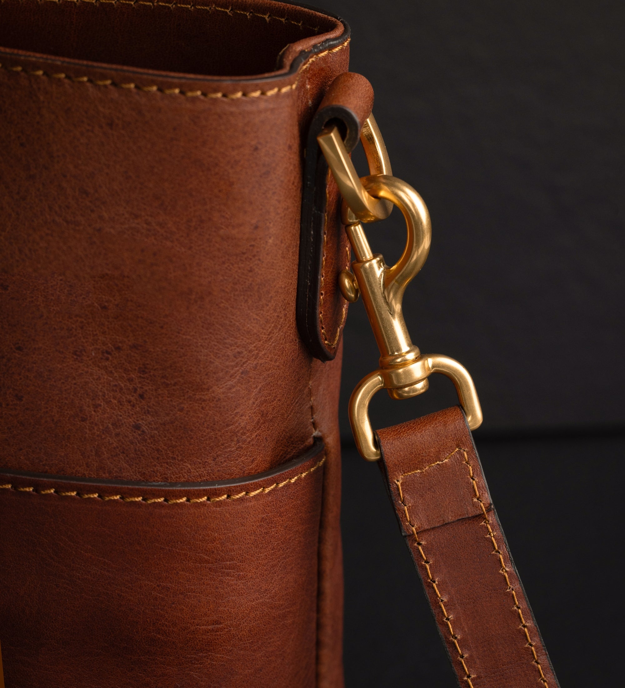 Nahaufnahme des Karabiners am Schulterriemen und der D-Ring-Beschläge der cognacbraunen Camilla Schultertasche