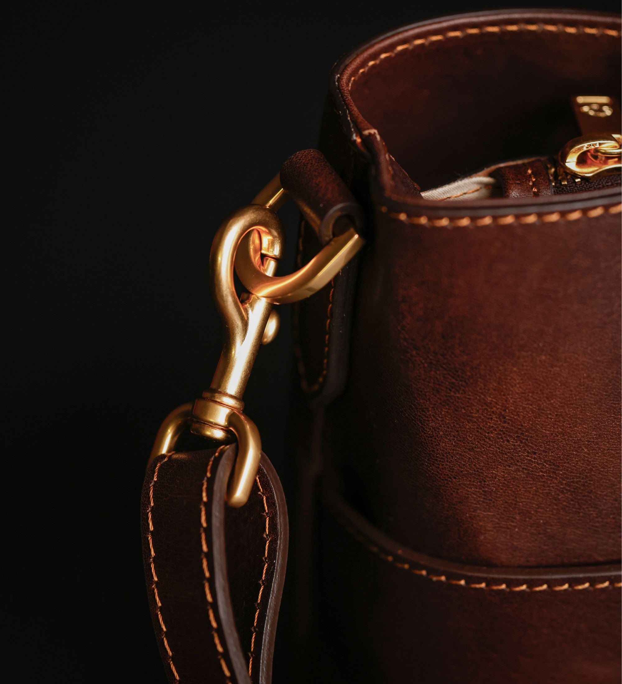 Nahaufnahme des goldfarbenen Verschlusses der schokoladenbraunen Camilla Schultertasche
